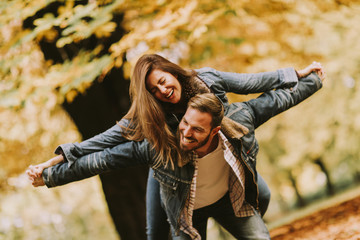 Young loving couple having fun in the autumn park