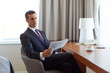 © Syda Productions - businessman reading newspaper at hotel room