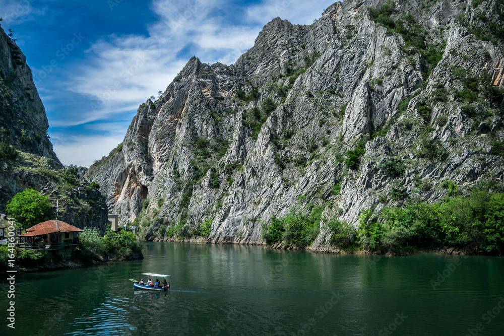 Motor boat in the lake of Canyon Matka in Macedonia - obrazy, fototapety, plakaty 