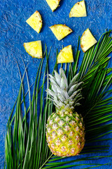  Ananasa i palmy gałąź na błękita stołu tła odgórnym widoku