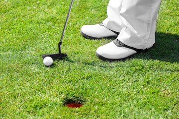 Wall Mural - Legs of young man playing golf on course in sunny day