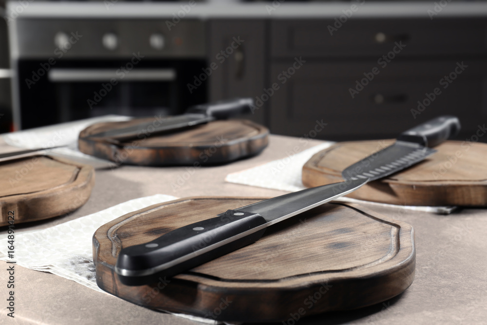 Knife and wooden board on kitchen table. Cooking classes concept