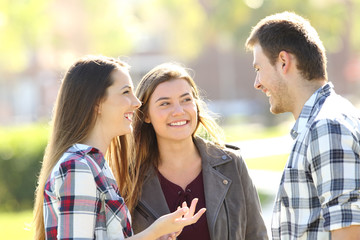 Wall Mural - Three happy friends talking in the street