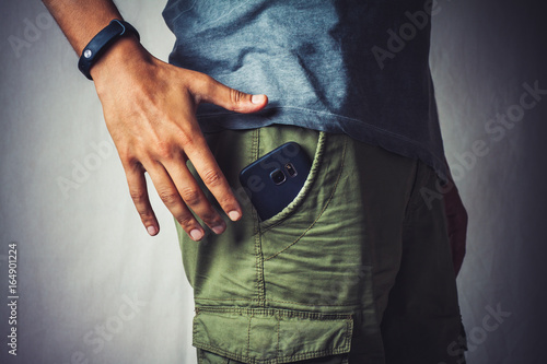 Cuadros en Lienzo close-up of a hand about to taking a smart phone from a pant's pocket