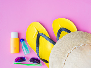 Wall Mural - Sunglasses with summer hat, flip flops, shampoo  and sunscreen lotion  on pink background.Vacation and relaxation, summer travel concept.