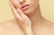 © Africa Studio - Closeup view of beautiful young woman with natural lips makeup touching face on color background