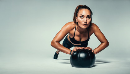 Wall Mural - Fit woman doing push up on medicine ball