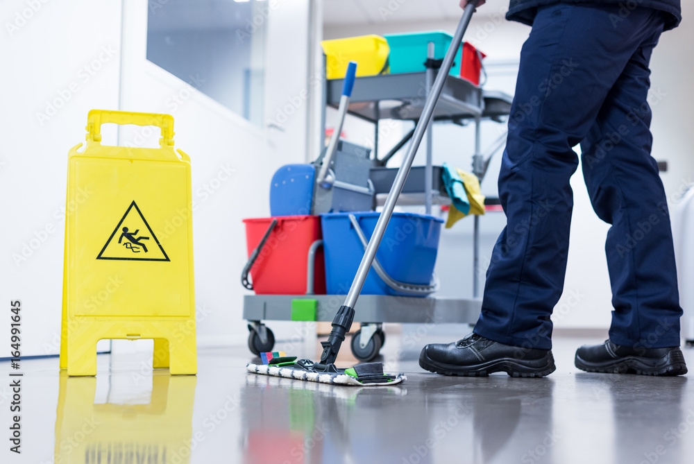 Worker janitor Mopping Floor In Office with trolley