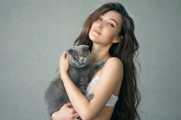 Beautiful brunette girl in underclothes with cat resting at home