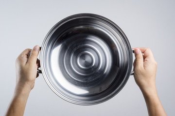 Hand holding stainless steel pan or wide pot