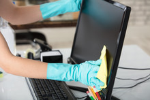 Woman Cleaning Desktop Screen With Rag