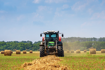 Aufkleber - Tractor in a farmer field with balls of straw.