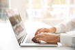 © Africa Studio - Male hands typing on laptop at office