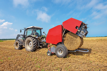 Aufkleber - Tractor in a farmer field with balls of straw.