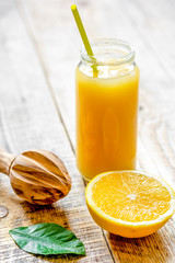 freshly squeezed orange juice in glass bottle on wooden backgrou