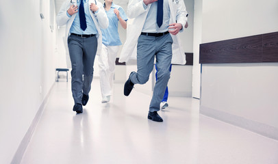 close up of medics or doctors running at hospital