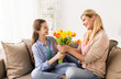 © Syda Productions - happy girl giving flowers to mother at home