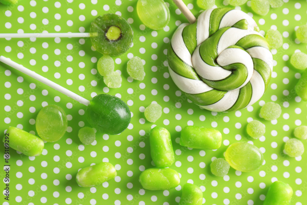 Tasty candies on patterned color background