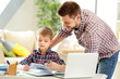 © Africa Studio - Father and son doing homework together at home