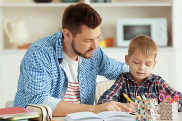 Canvas Print - Father and son doing homework together at home