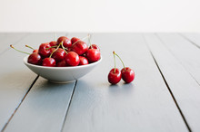 A Bowl Of Ripe Red Cherries On A Grey Table