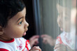 © Saptak Ganguly/Stocksy - Baby girl looking amazed at her reflection on a window glass
