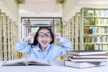 Wall Mural - Cheerful girl celebrating her success in library