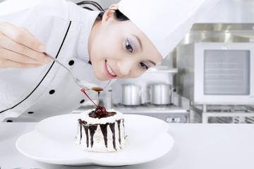 Female chef preparing sweet cake