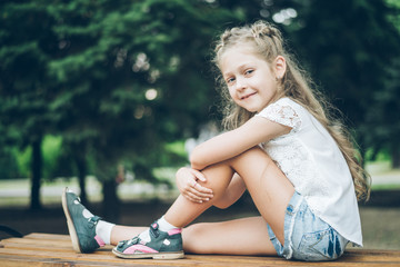 Cute little blond girl in summer clothes outdoor