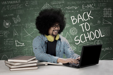 Male student with laptop in the classroom