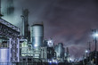 © yuko hirao/Stocksy - Busy chemical factories at night next to a residential area