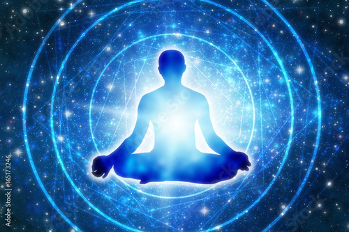 Fotomural silhouette of a man sitting in a yoga pose of lotus over blue Universe like a co