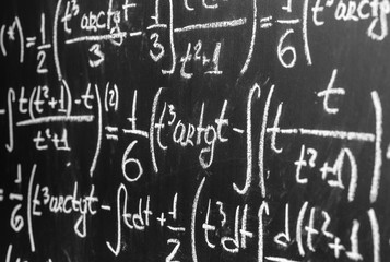 Back to school background with math formulas are written by white chalk on the black chalkboard
