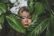 © Rob and Julia Campbell/Stocksy - Cute, sad toddler boy crying in the bushes with face covered in mud - funny