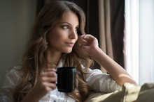 A Young Brunette Relaxing With A Cup Of Coffee