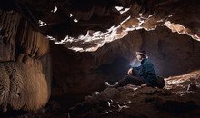 Man In Underground Cave With Limestone Formations