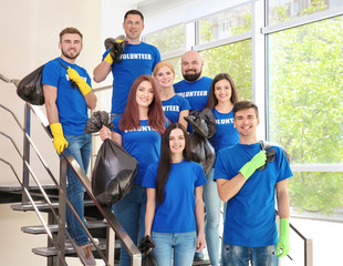 Canvas Print - Young volunteers with garbage bags on staircase