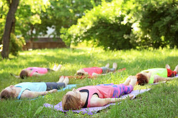 Sticker - Group of young women practicing yoga outdoors