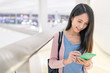 © leungchopan - Woman use of mobile phone in airport