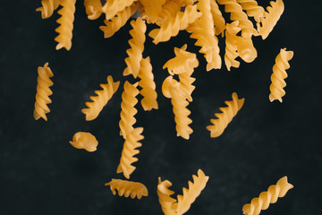 Flying pasta on dark background. Food motion.