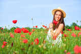 Fototapeta Tulipany - A happy woman in the field of red poppies