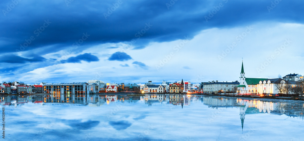Obraz na płótnie Beautiful panorama of the skyline cityscape of Reykjavik, reflected in lake Tjornin at the blue hour in winter w salonie