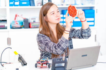 Canvas Print - Schoolgirl in the school robotics laboratory with a robot model