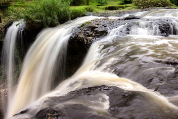 a very beautiful waterfall, water falling from a river, A close up view of water falling over, background