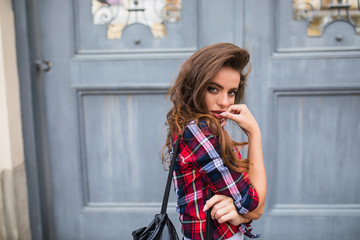 Wall Mural - Young beautiful girl in stylish clothes posing in the city street