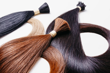 hair extensions of three colors on a white background. copyspace selective focus