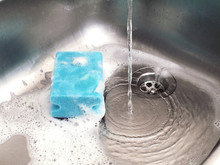 Sponge In Kitchen Sink Under Running Water