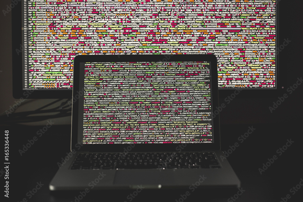 Laptop screen with source code in front of the bigger display Stock ...