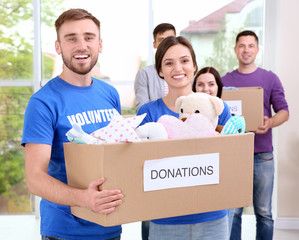 Canvas Print - Young volunteers with box of donations indoors