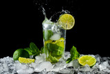 Mojito, a cool cocktail of lime and mint and soda, in a highball glass with a splash and ice, isolated on a black background